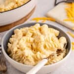 High Protein Mac and Cheese in a bowl with the skillet in the back