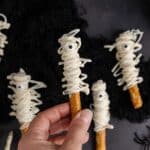 Mummy Pretzel Rods from above with one being held