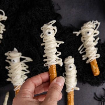 Mummy Pretzel Rods from above with one being held