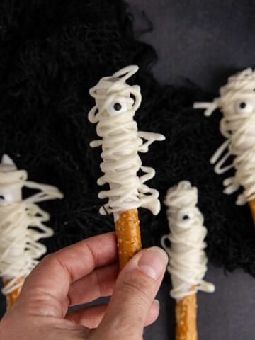 Mummy Pretzel Rods from above with one being held