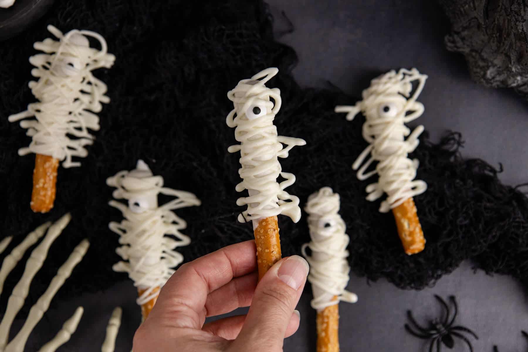 Mummy Pretzel Rods from above with one being held