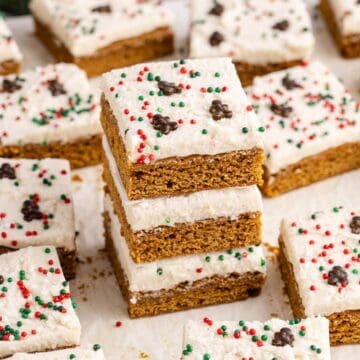 Gingerbread Cookies Bars with Icing and sprinkles on parchment paper stacked