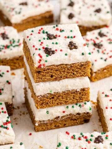 Gingerbread Cookies Bars with Icing and sprinkles on parchment paper stacked