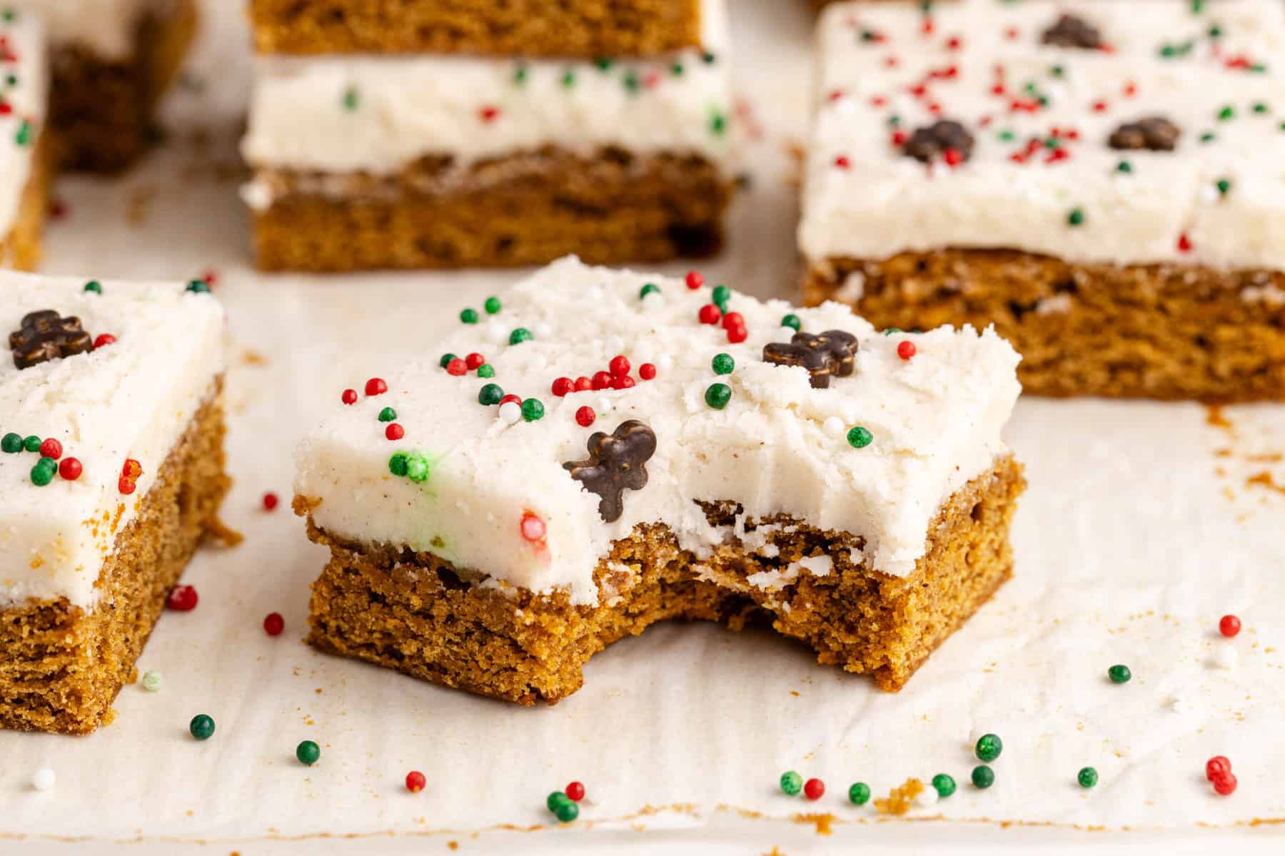 Gingerbread Cookies Bars on parchment paper with a bite taken