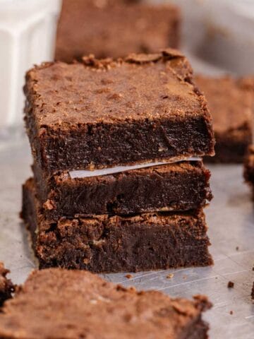 Old Fashioned Sheet Pan Brownies stacked on a baking sheet