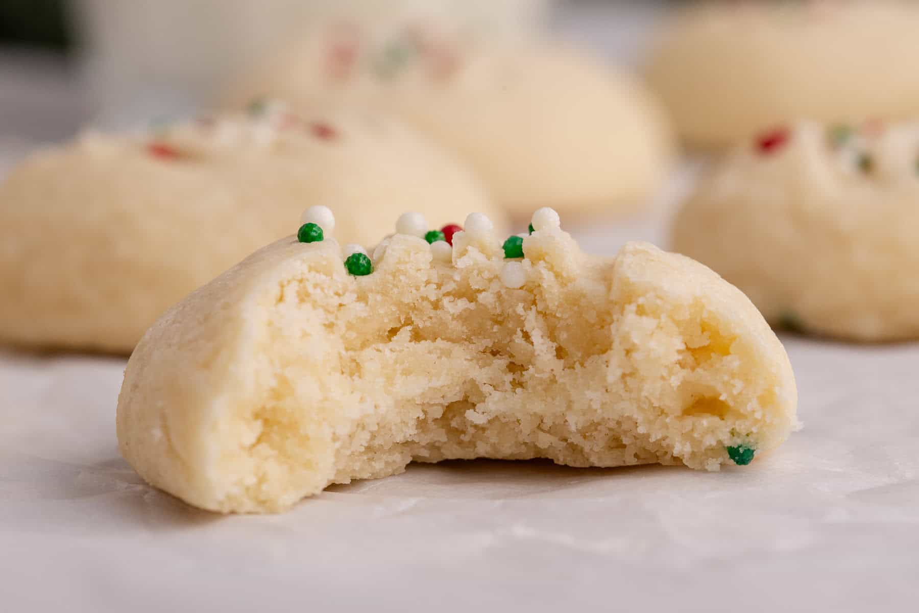 Whipped Shortbread Cookie with a bite taken up close to see the light texture